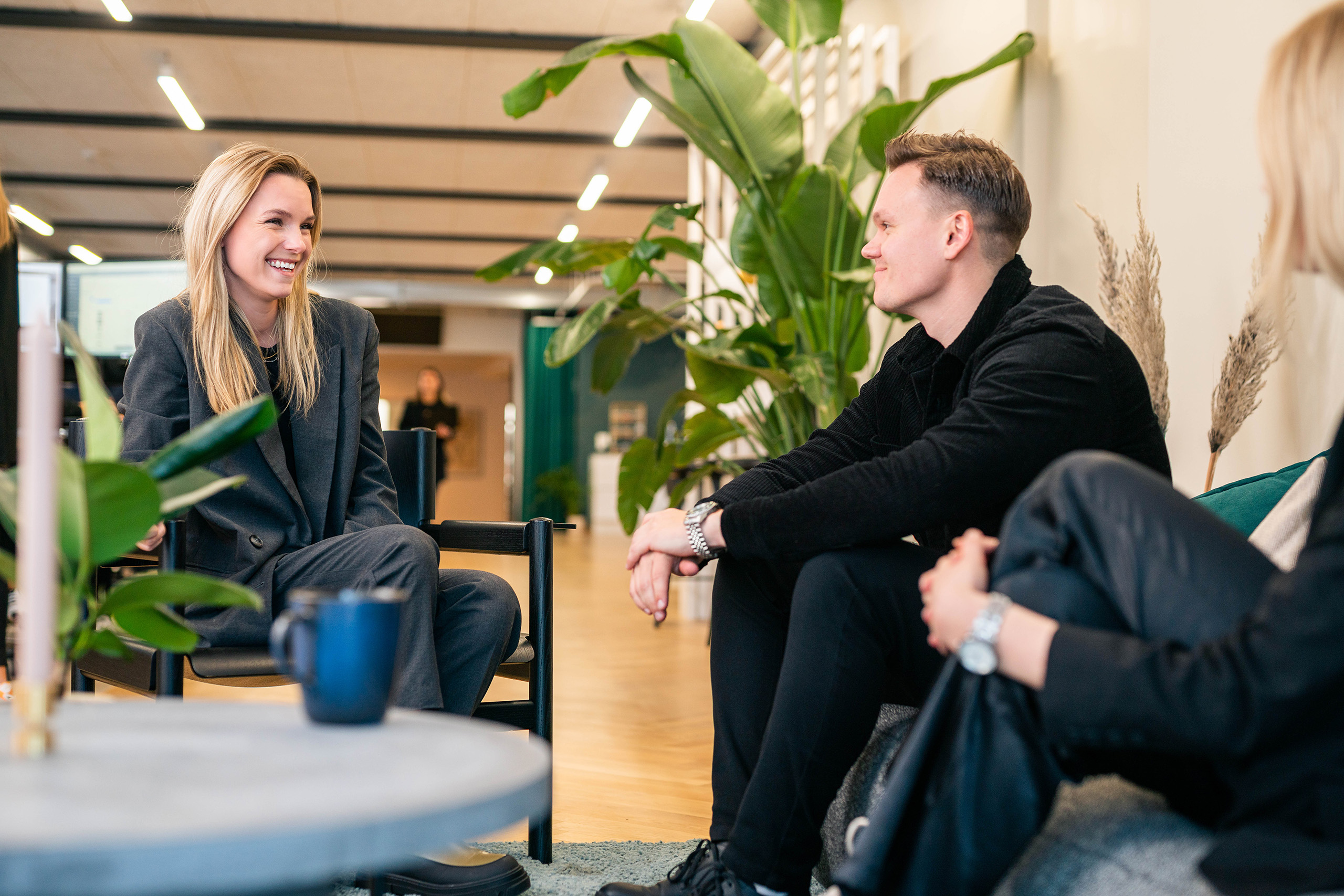 Billede af to ansatte der sidder overfor hinanden og smiler